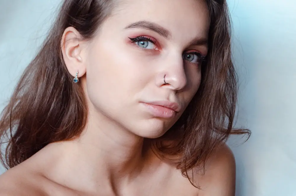 Beautiful young woman with pierced nose ring and bright make-up