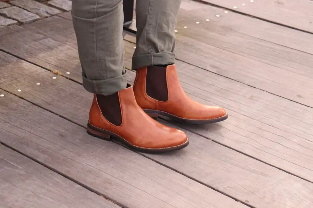 Light tan Chelsea Boots on a boardwalk, for a simple fashion picture of men's style