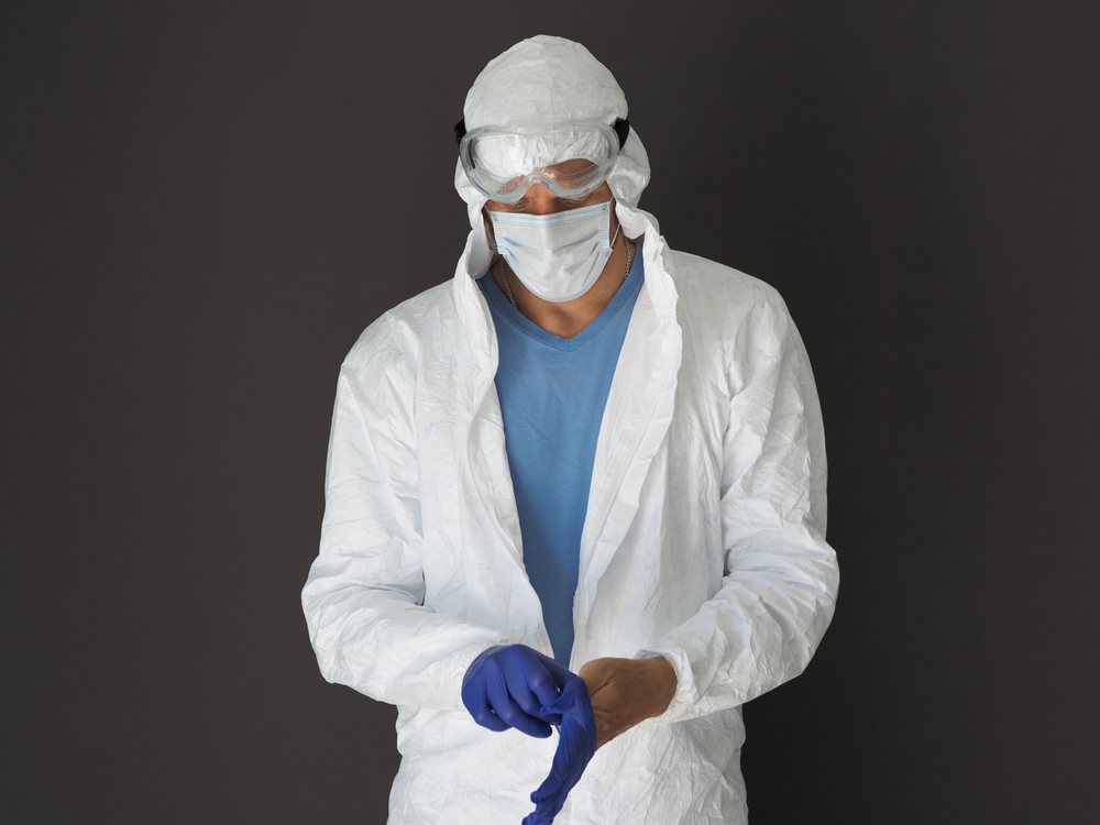 Man dressing in White Coverall Suit with Hood