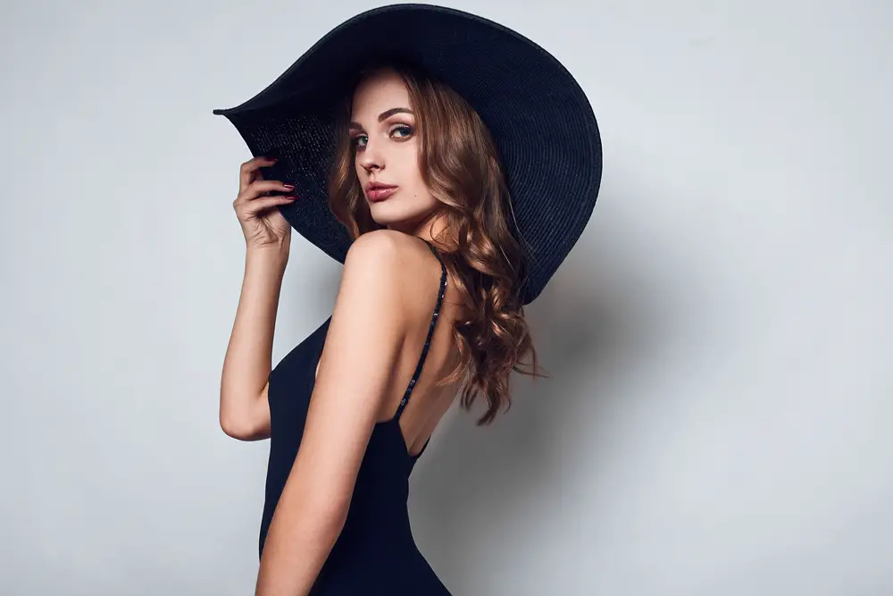 beautiful woman in a black dress and wide hat