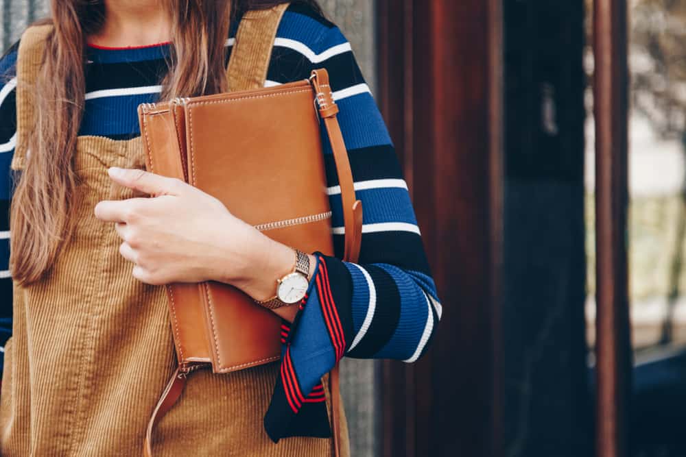 corduroy dress and a white and golden analog wrist watch