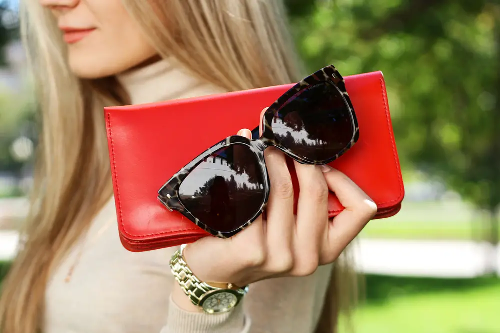 fashion young woman hold red purse in hand with black trendy sunglasses