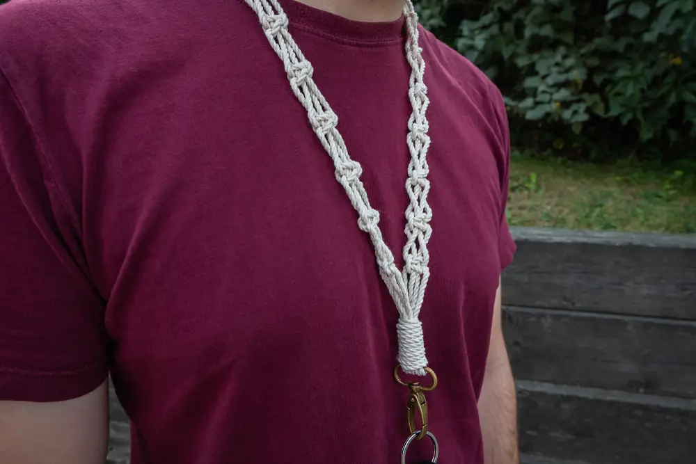 man is wearing a long macrame keychain - lanyard around his neck