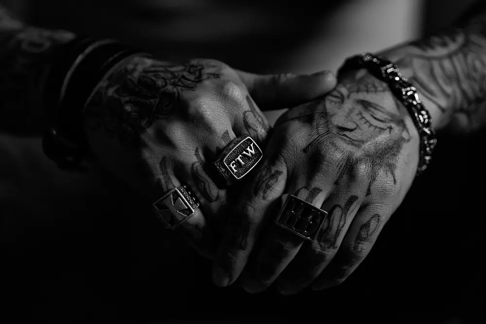 male tattoo artist wearing jewelry and rings
