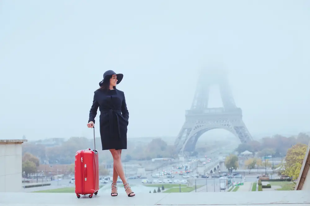 woman with luggage near Eiffel Tower
